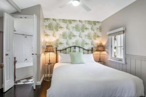 a bedroom with a large bed and a bath tub at Cottage 2 Hyams Beach Seaside Cottages in Hyams Beach