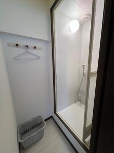 y baño con ducha y espejo. en ホテルペナ101, en Tokio