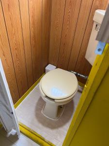 baño con aseo en una pared de madera en ホテルペナ101, en Tokio
