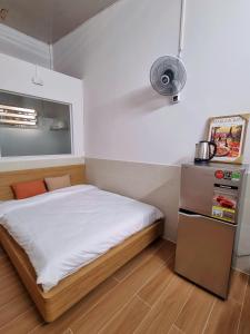 カントーにあるTran Phu Riverside Houseの小さなベッドルーム(ベッド1台、冷蔵庫付)
