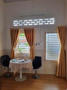 カントーにあるTran Phu Riverside Houseのテーブルと椅子2脚と窓のある部屋 +64枚の写真