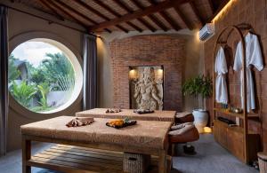a dining room with a table and a large window at Lalasa Villas Canggu in Canggu