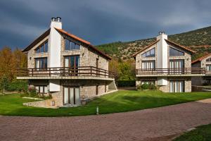 a large stone house with a green yard at Naiades Village in Polydrossos