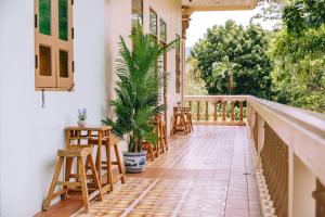 a porch with chairs and a table and a plant at O'nya Phuket Hotel in Phuket