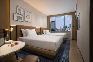 2 letti in camera d'albergo con vista di Four Points by Sheraton Kunming Dongfeng Square a Kunming