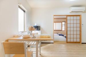 ein Esszimmer mit einem Tisch und ein Schlafzimmer in der Unterkunft Cozy condo for 2 PPL near Teradacho Sta 4 min walk cecilia301 in Osaka