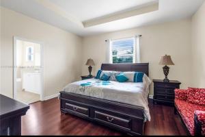 a bedroom with a bed and a red chair at Aloha in Homestead