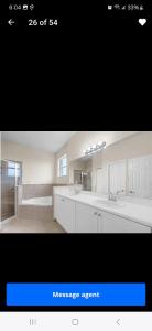 a bathroom with two sinks and a large mirror at Aloha in Homestead