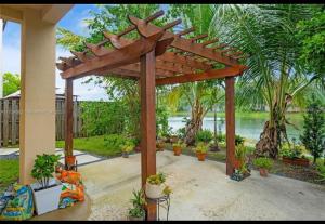 a wooden pergola with potted plants on a patio at Aloha in Homestead
