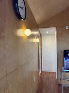 a clock on the wall of a hallway with a door at Kimnung House Anmok in Jeju