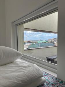 a bedroom with a window with a view of a bridge at Kimnung House Anmok in Jeju