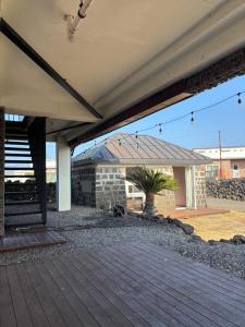 a patio with a building with a roof at Kimnung House Anmok in Jeju