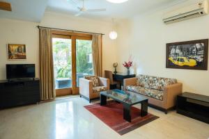 a living room with a couch and a tv at Ahuja Residency Cyber City I in Gurgaon
