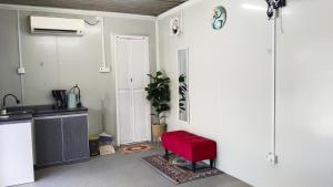 a kitchen with a red chair in a room at Casa LiLa Tiny Cabin Studio Stay & Pool Kota Bharu,free wifi,free parking in Kampong Seribang