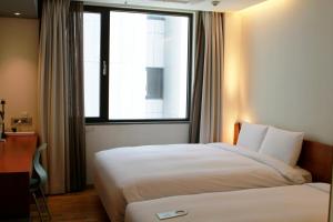 una camera d'albergo con due letti e una finestra di Seoul Hotel ShinShin Myeongdong a Seul