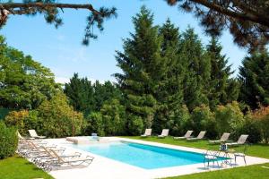 - une piscine dans une cour avec des chaises et des arbres dans l'établissement Château de Fleurville & Spa - Les Collectionneurs, à Fleurville