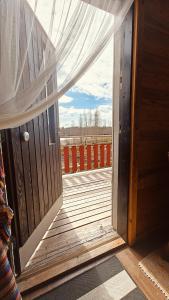 an open door to a deck with a window at BB Polle - with the horse view in Mikkeli