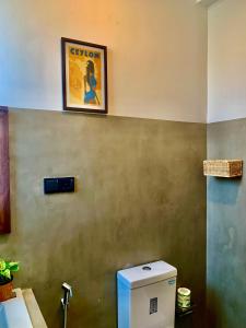 a picture on the wall above a toilet in a bathroom at Thaproo Bay Hiriketiya in Dickwella +99 photos