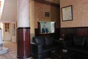 un homme debout dans un miroir dans un salon dans l'établissement Hotel Saint Georges Tunis, à Tunis