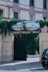 une porte menant à un bâtiment avec un panneau au-dessus de celui-ci dans l'établissement Hotel Saint Georges Tunis, à Tunis