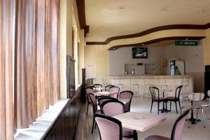 a dining room with tables and chairs and a bar at Hotel Saint Georges Tunis in Tunis