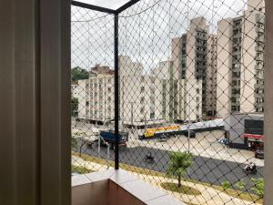 a view of a city street from a window at Apto aconchegante pertinho da praia in Guarujá