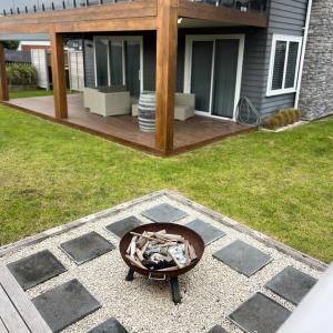 a backyard with a fire pit on a patio at Sea Mist in Ohope Beach +4 photos