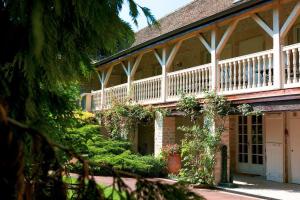 une grande maison avec un balcon blanc et des plantes dans l'établissement Château de Fleurville & Spa - Les Collectionneurs, à Fleurville