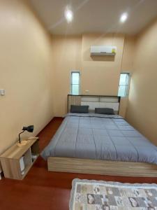 a bedroom with a large bed in a room at Twinstail in Ban Nong Chaeng