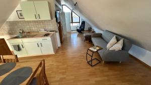 Una sala de estar con un sofá y una cocina. en Ferienwohnung Eifelmond, en Nettersheim 2 fotos más