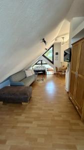 Una sala de estar con un sofá y un televisor. en Ferienwohnung Eifelmond, en Nettersheim