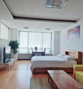 仁川市Cozy - Experience Home like Comfort Studio的一间带一张大床和一张沙发的大卧室