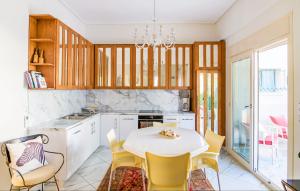 a kitchen with a white table and yellow chairs at Central Luxurious Retreat in Argostoli
