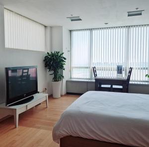 仁川市Cozy - Experience Home like Comfort Studio的一间带床和平板电视的卧室