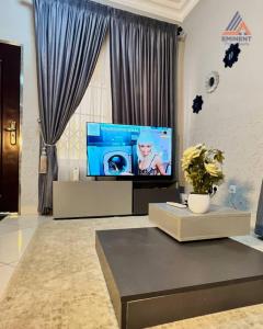 a living room with a flat screen tv and a table at Jessica's Villa in Accra