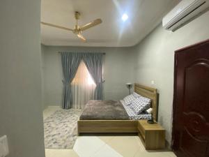 a bedroom with a bed and a ceiling fan at Jessica's Villa in Accra +17 photos