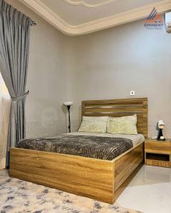a bedroom with a wooden bed in a room at Jessica's Villa in Accra