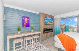 a bedroom with a blue wall with a bed and a fireplace at Ocean Front Beach'n 1BR Premium Condos in Myrtle Beach