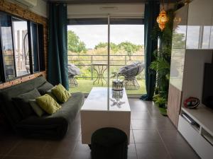 a living room with a couch and a table at Appartement de L'Espiguette in Le Grau-du-Roi