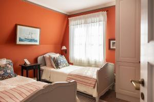 two beds in a room with orange walls at The Pilot House, Sandhamn, Stockholm Archipelago in Sandhamn