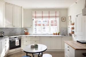 a white kitchen with a table and a window at The Pilot House, Sandhamn, Stockholm Archipelago in Sandhamn +6 photos