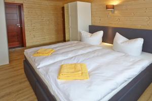 a large white bed with two towels on it at La Porte in Bertingen +70 photos