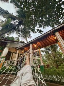 uma pessoa deitada numa rede em frente a uma casa em Casa Amore em Benaulim