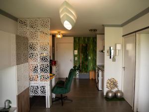a living room with a green chair and a table at Appartement de L'Espiguette in Le Grau-du-Roi