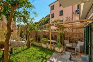 a garden with a pergola and a table and chairs at La Casa di Luna in Riomaggiore