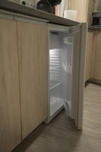 an empty refrigerator with its door open in a kitchen at Smart Apartament in Braşov