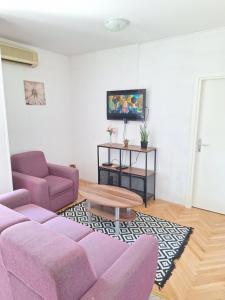 Una sala de estar con un sofá morado y una mesa. en Apartment Matilda, en Split