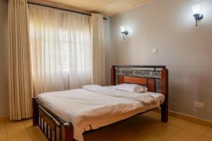 a small bed in a room with a window at Gatundu Slow Life Farm Stay and Hiking in Tea Farms in Kangunyi