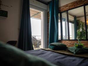 a bedroom with a bed and a large window at Appartement de L'Espiguette in Le Grau-du-Roi