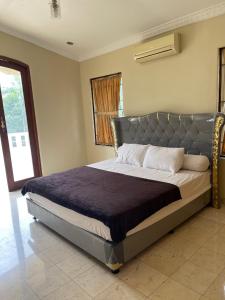 a bedroom with a large bed with a metal headboard at Vila Sentul Private pool 6bedroom, 5bathroom, Privatepool tennis meja, Billiard, 0813delapannolsatuenam4151 in Gadok 1